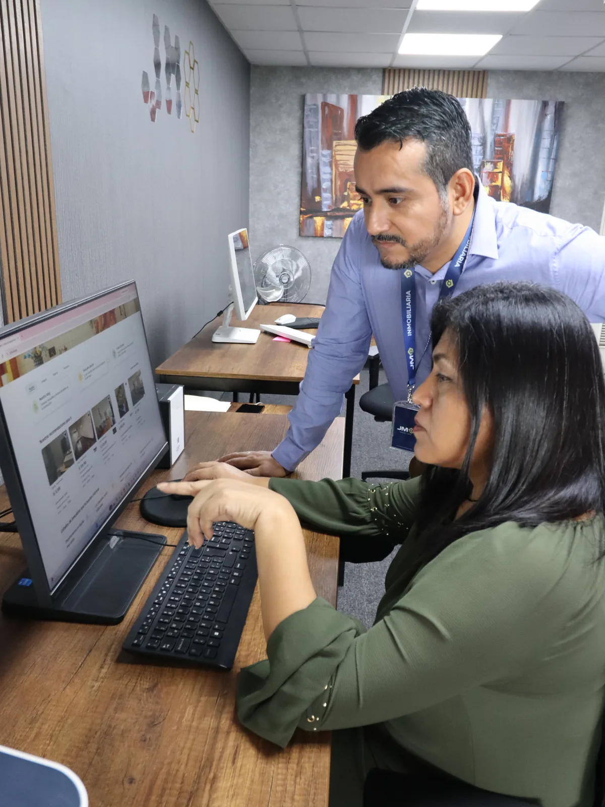 Luis Castañeda y Lidia Guardamino revisando un aviso en pantalla